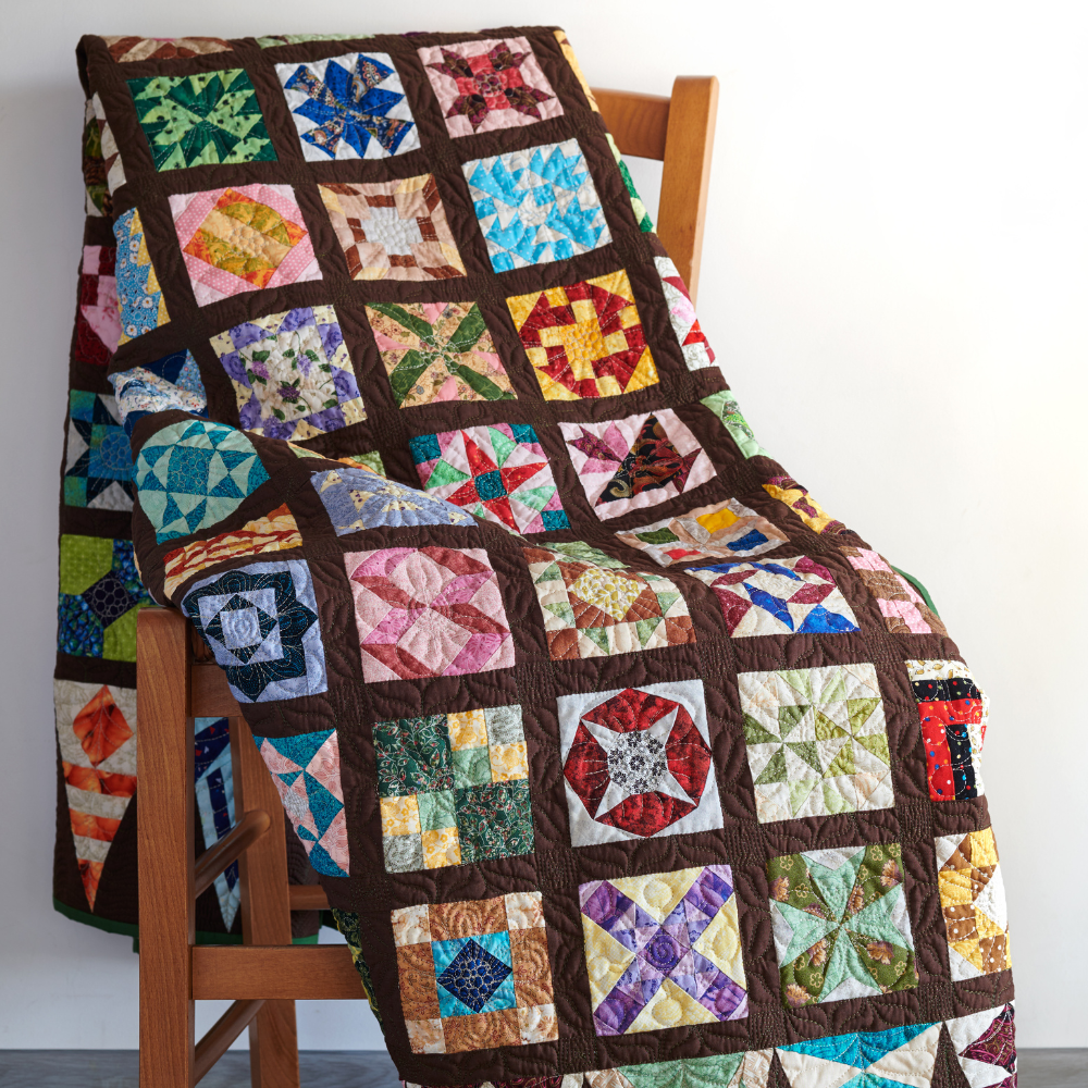 quilt with colorful patches draped over chair